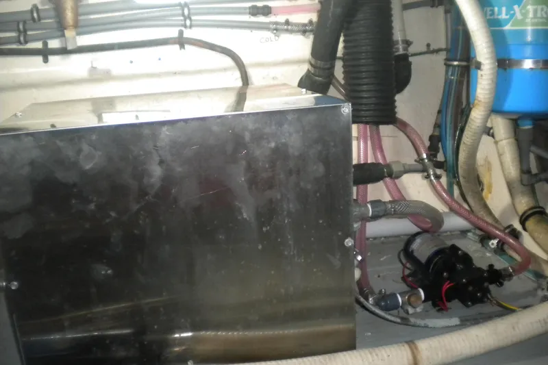 Slide: The Image of Engine room of 1987 Hatteras 40 Motor Yacht with mechanical components and hoses. - 44