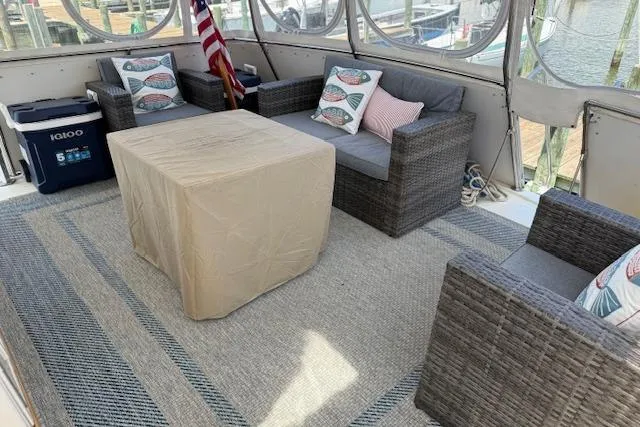 Slide: The Image of Cozy seating area on 1987 Hatteras 40 Motor Yacht with wicker furniture and nautical decor. - 5