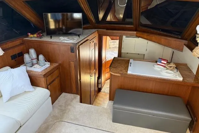 Slide: The Image of 1987 Hatteras 40 Motor Yacht interior with cozy seating, TV, and wooden cabinetry. - 7