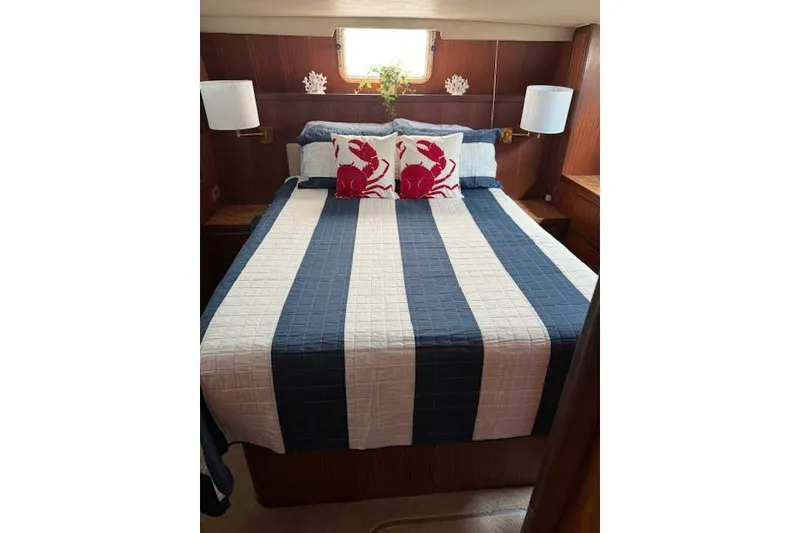 Slide: The Image of Cozy bedroom in 1987 Hatteras 40 Motor Yacht with nautical decor and striped bedding. - 9