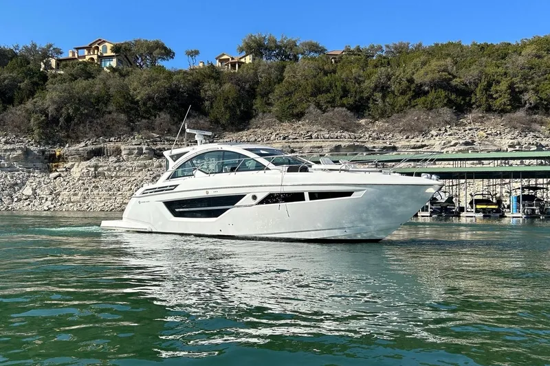 Slide: The Image of 2021 Cruisers Yachts 50 Cantius on serene water with scenic backdrop. - 10