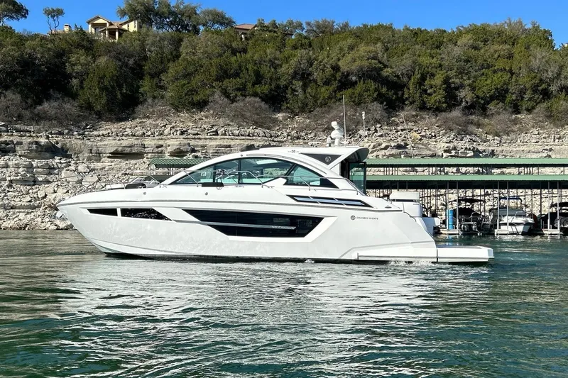Slide: The Image of 2021 Cruisers Yachts 50 Cantius on serene water near rocky shoreline. - 17