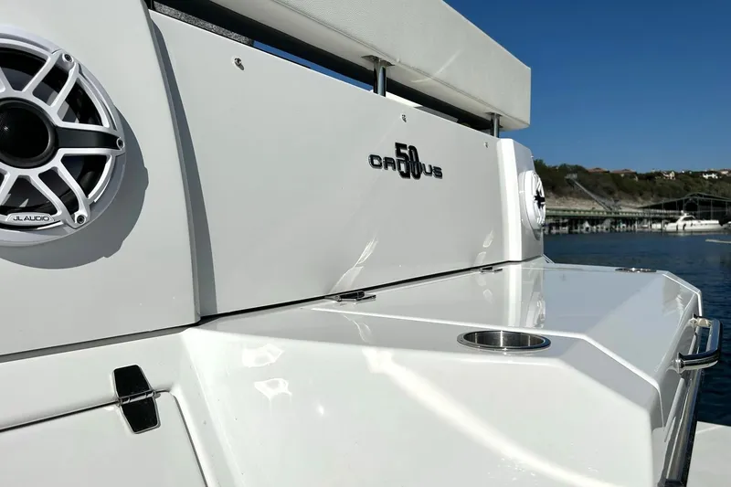 Slide: The Image of 2021 Cruisers Yachts 50 Cantius boat with JL Audio speakers, docked by the water. - 27