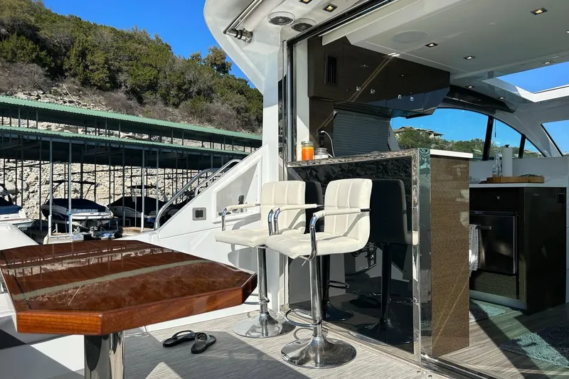 Slide: The Image of 2021 Cruisers Yachts 50 Cantius interior with bar stools and table, docked near marina. - 34