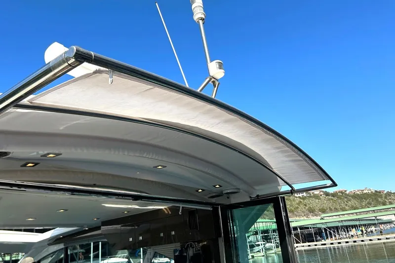 Slide: The Image of 2021 Cruisers Yachts 50 Cantius with sleek canopy and modern design against clear blue sky. - 37