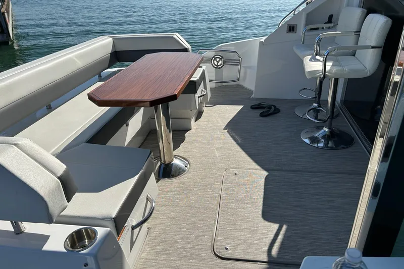 Slide: The Image of 2021 Cruisers Yachts 50 Cantius deck with seating and table, overlooking water. - 4