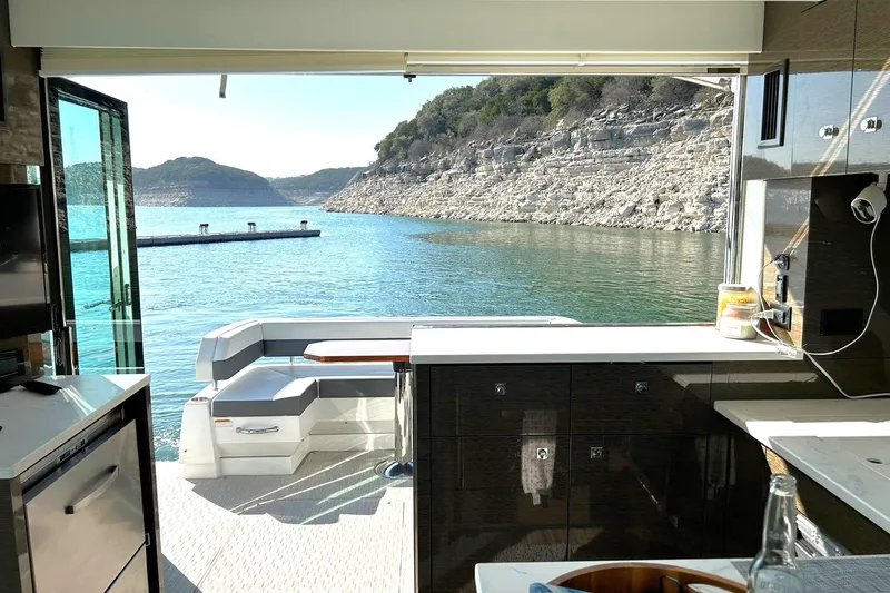 Slide: The Image of Interior view of 2021 Cruisers Yachts 50 Cantius overlooking serene lake and rocky shoreline. - 49