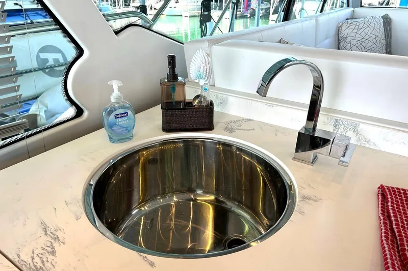 Slide: The Image of Modern yacht kitchen sink with faucet, soap, and towel on 2021 Cruisers Yachts 50 Cantius. - 55