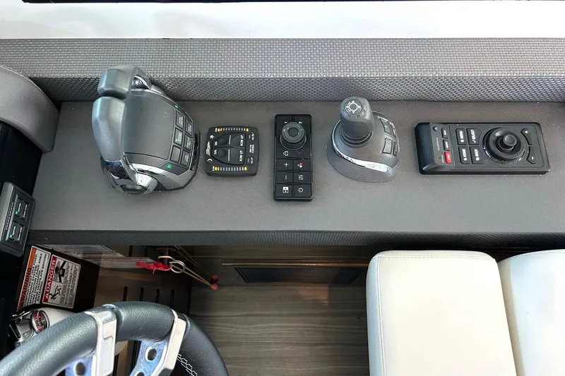 Slide: The Image of Control panel of 2021 Cruisers Yachts 50 Cantius with joystick and throttle controls. - 64