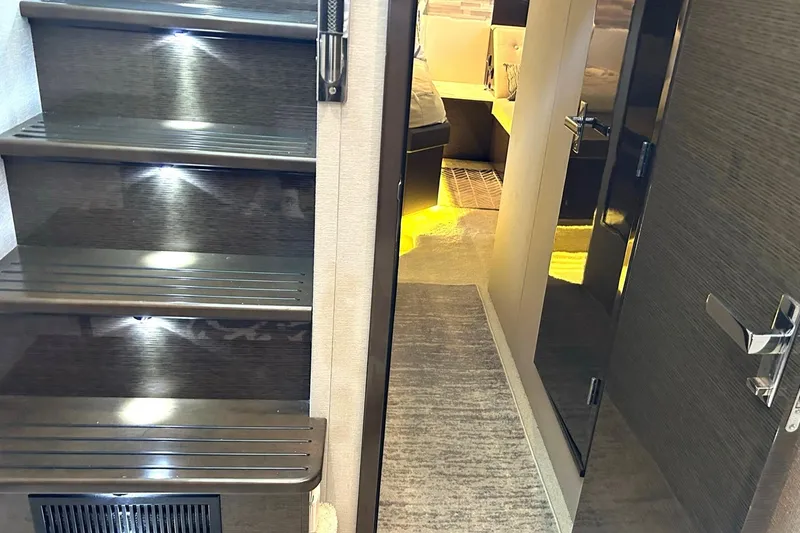 Slide: The Image of Interior of 2021 Cruisers Yachts 50 Cantius, featuring illuminated stairs and modern design. - 70