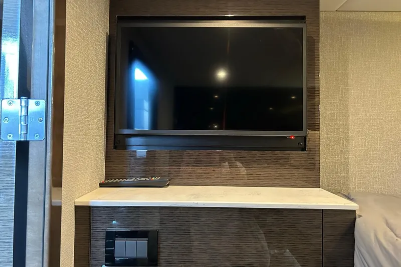 Slide: The Image of Interior of 2021 Cruisers Yachts 50 Cantius with mounted TV and remote control. - 95