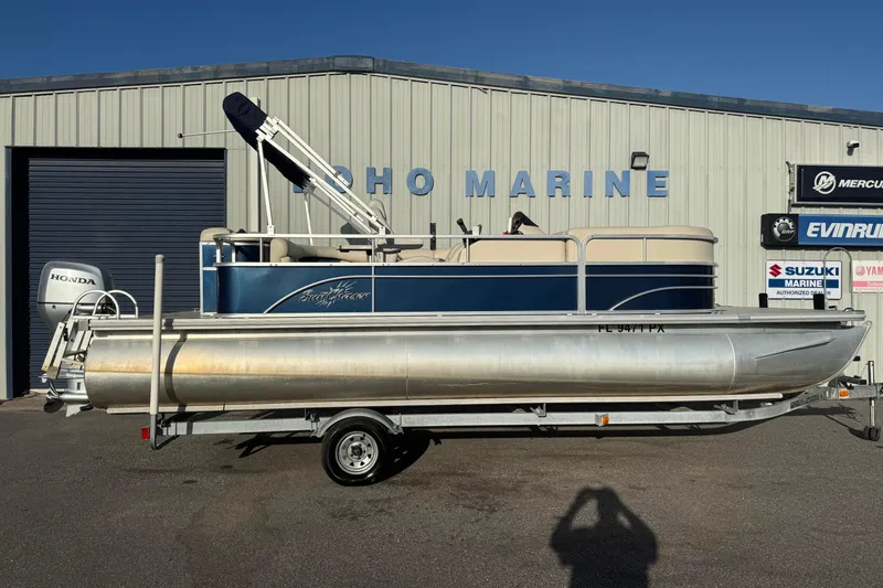 The Image of 2015 SunChaser 22 VS pontoon boat on trailer outside marine dealership. - 0