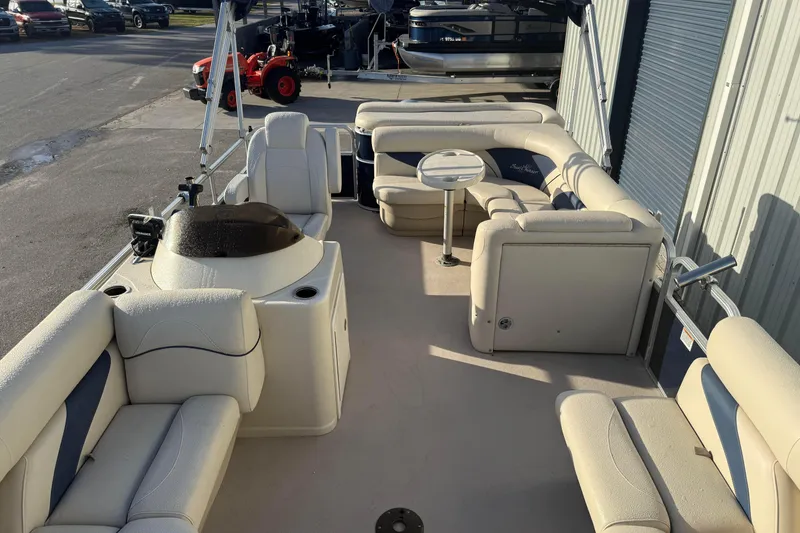 Slide: The Image of 2015 SunChaser 22 vs pontoon boat interior with beige seating and compact table. - 7