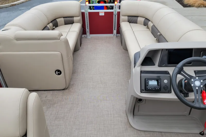Slide: The Image of 2024 Sun Tracker Party Barge 20 DLX interior with beige seating and modern dashboard. - 9