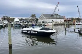 The Image of 2022 Monterey boat docked in a marina with cranes and buildings in the background. - 1