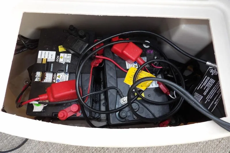 Slide: The Image of Battery compartment of a 2018 Bennington 23SF boat with cables and connections. - 13