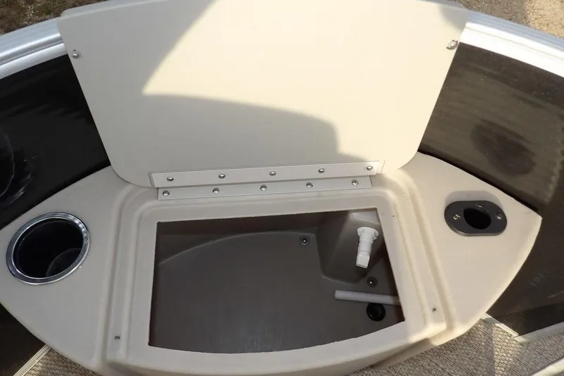 Slide: The Image of Open storage compartment on a 2018 Bennington 23SF boat with cup holders. - 22