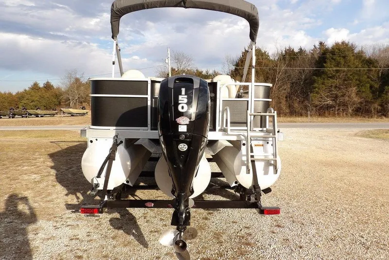 Slide: The Image of 2018 Bennington 23SF pontoon boat with powerful outboard motor, parked on gravel. - 3
