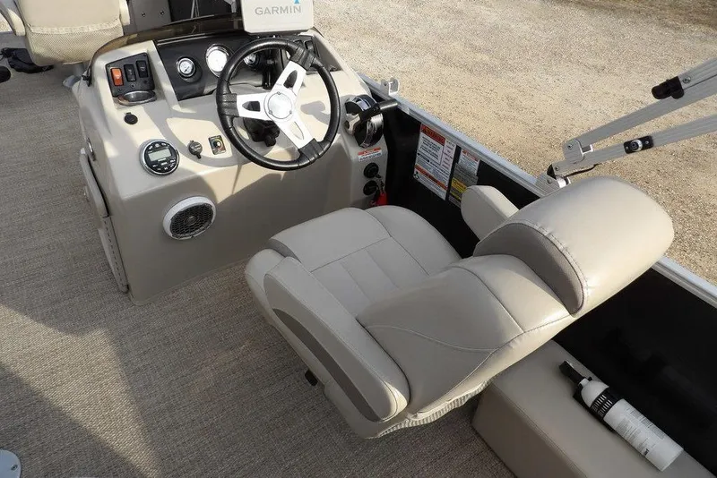 Slide: The Image of 2018 Bennington 23SF boat helm with steering wheel, gauges, and beige captain's chair. - 30