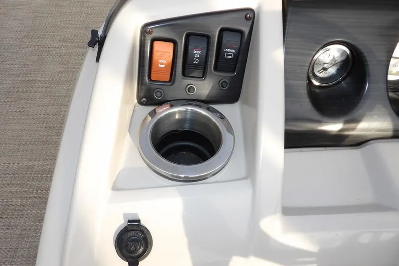 Slide: The Image of Control panel of a 2018 Bennington 23SF boat with switches and cup holder. - 31