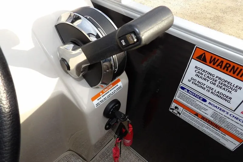 Slide: The Image of Throttle control and warning labels on a 2018 Bennington 23SF boat dashboard. - 37