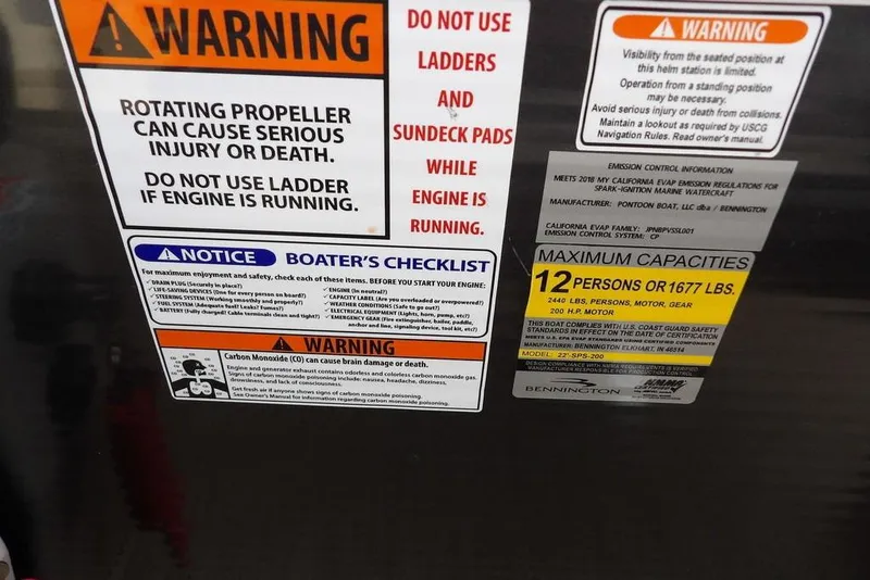 Slide: The Image of Warning and safety labels on a 2018 Bennington 23SF boat, including capacity and engine instructions. - 40
