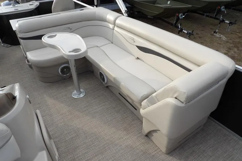 Slide: The Image of 2018 Bennington 23SF boat interior with beige seating and a small table. - 42
