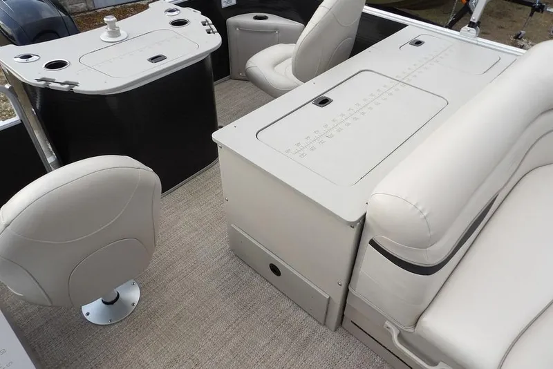 Slide: The Image of 2018 Bennington 23SF boat interior with beige seating and storage compartments. - 47