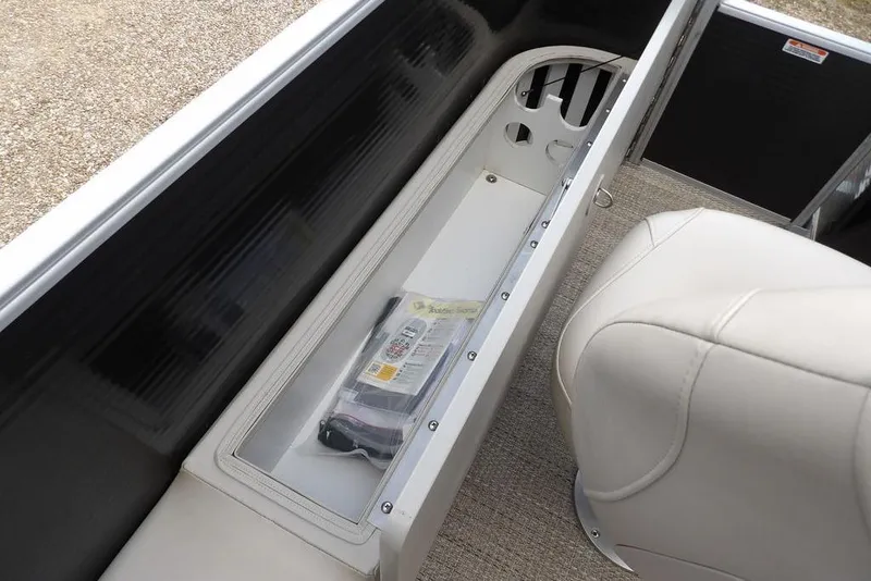 Slide: The Image of 2018 Bennington 23SF boat storage compartment with beige seating and accessories. - 48