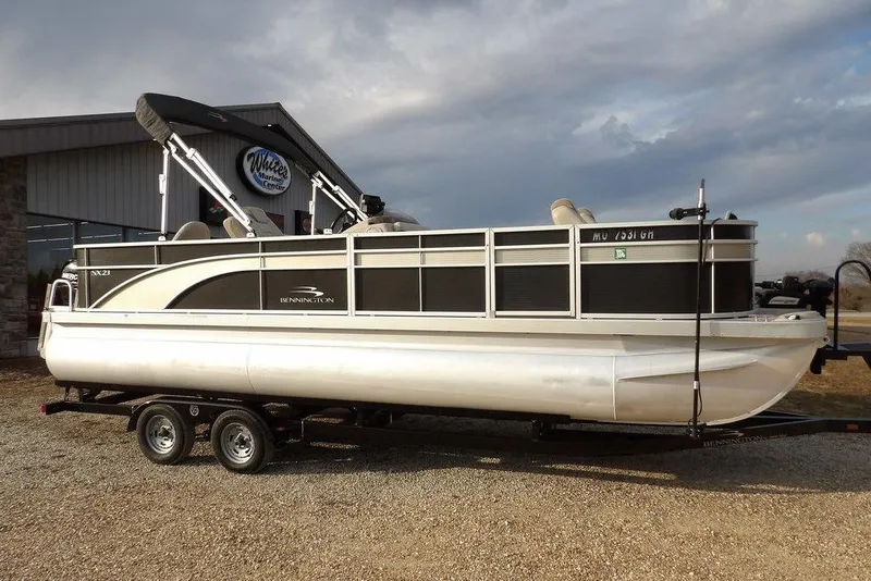 Slide: The Image of 2018 Bennington 23SF pontoon boat on trailer, parked outside marine center. - 65