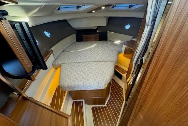 Slide: The Image of 2025 Ranger Tug R-29 CB Luxury Edition interior with cozy bed and wooden accents. - 11