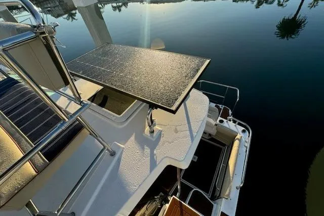 Slide: The Image of 2025 Ranger Tug R-29 CB Luxury Edition with solar panel, docked on calm water. - 18
