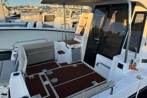 Slide: The Image of 2025 Ranger Tug R-29 CB Luxury Edition boat deck with seating and wood flooring. - 5