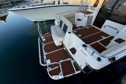 Slide: The Image of 2025 Ranger Tug R-29 CB Luxury Edition with elegant deck design and seating at the marina. - 6