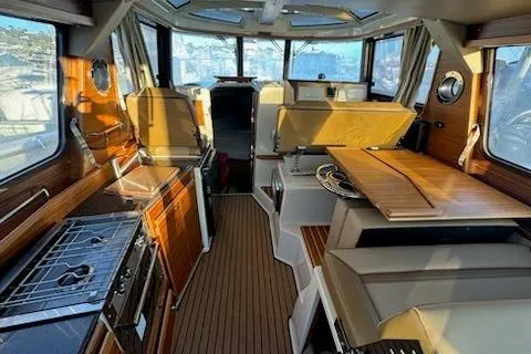 Slide: The Image of 2025 Ranger Tug R-29 CB Luxury Edition interior with modern kitchen and seating area. - 8