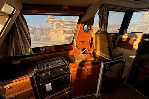 Slide: The Image of Interior of 2025 Ranger Tug R-29 CB Luxury Edition with kitchen and seating area. - 9