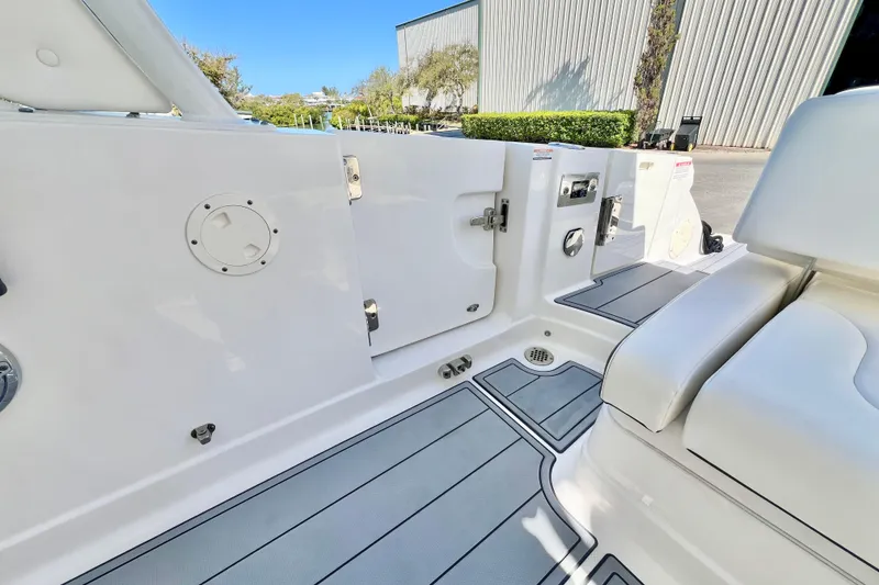 Slide: The Image of 2023 Chaparral 300 OSX boat interior with sleek white seating and modern deck design. - 13
