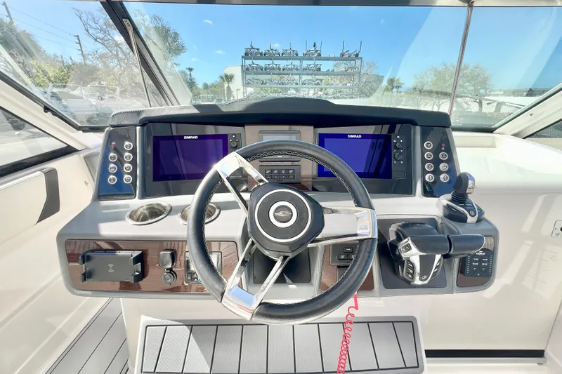 Slide: The Image of 2023 Chaparral 300 OSX boat dashboard with steering wheel and navigation screens. - 2