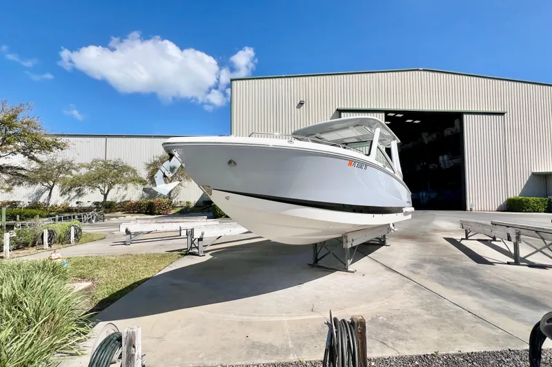 Slide: The Image of 2023 Chaparral 300 OSX boat on trailer outside large storage building. - 8