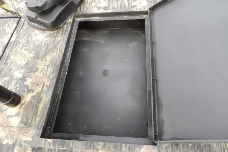 Slide: The Image of Open storage compartment on 2018 Crestliner 1660 Retriever boat with camouflage pattern. - 18