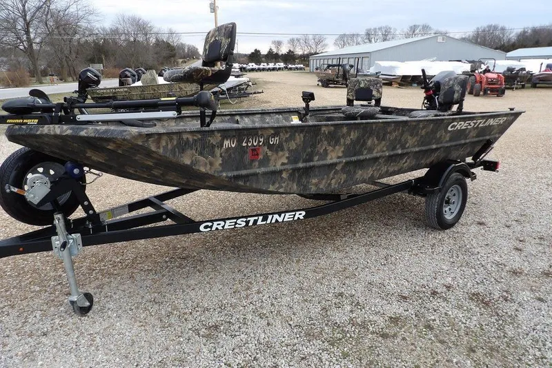 Slide: The Image of 2018 Crestliner 1660 Retriever boat with camouflage design on a trailer in a gravel lot. - 3