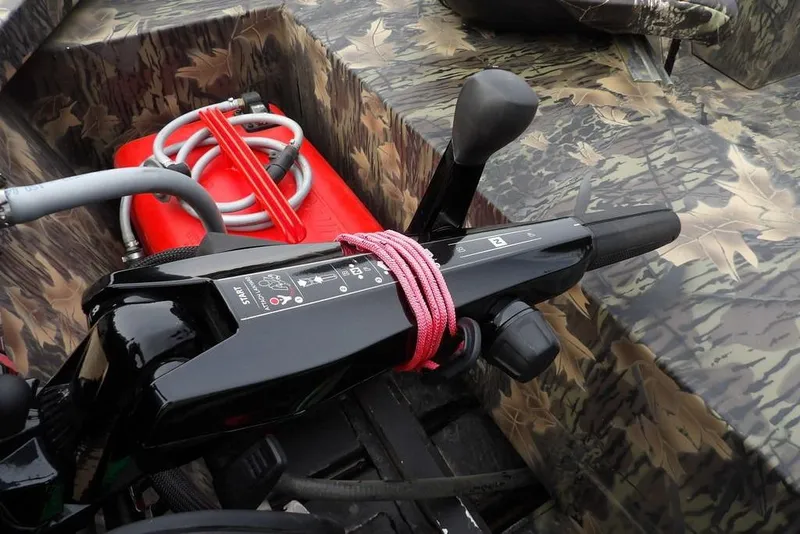 Slide: The Image of 2018 Crestliner 1660 Retriever boat controls with camouflage design and red fuel tank. - 31