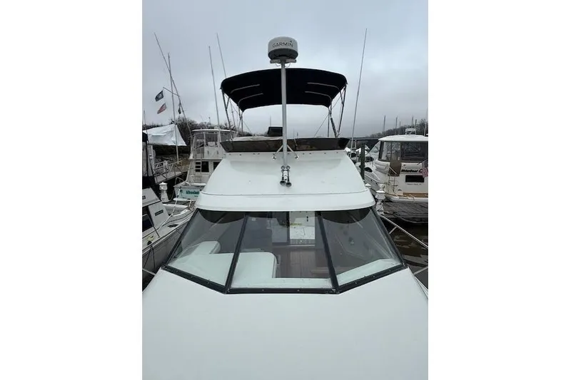 Slide: The Image of 1993 Silverton 34 Convertible boat docked, featuring a Garmin radar and black canopy. - 13