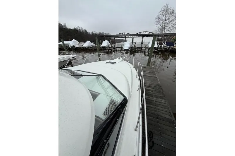 Slide: The Image of 1993 Silverton 34 Convertible docked near a bridge on a cloudy day. - 15