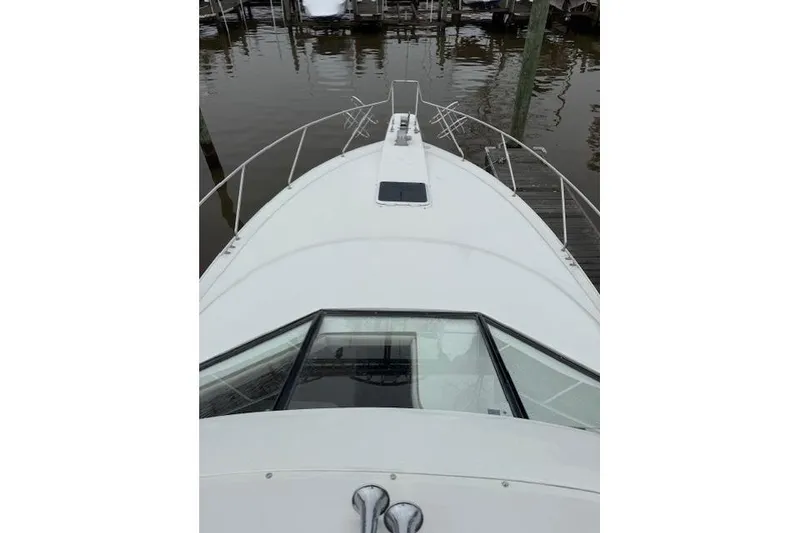 Slide: The Image of 1993 Silverton 34 Convertible boat bow view at dock, showcasing sleek design. - 16
