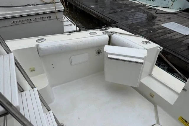 Slide: The Image of 1993 Silverton 34 Convertible boat interior with white seating and dock view. - 21