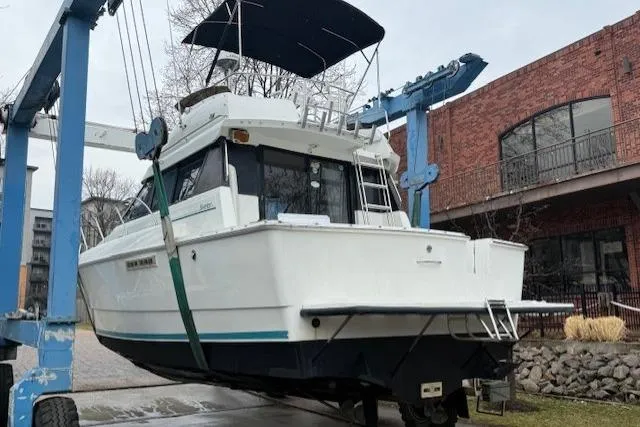 Slide: The Image of 1993 Silverton 34 Convertible boat on lift, near brick building, overcast sky. - 3