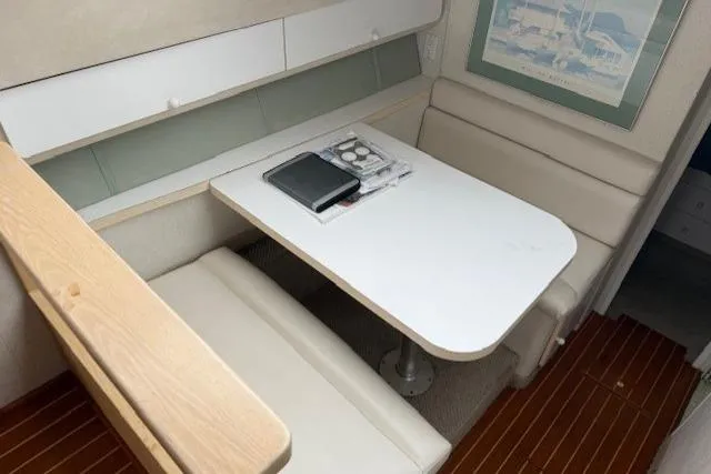 Slide: The Image of 1993 Silverton 34 Convertible interior with dining area, white table, and cushioned seating. - 37