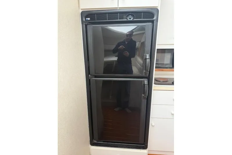 Slide: The Image of 1993 Silverton 34 Convertible yacht interior with a black refrigerator. - 42