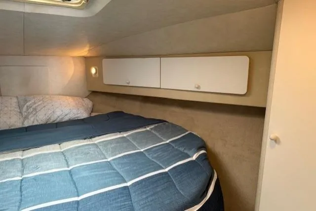 Slide: The Image of 1993 Silverton 34 Convertible cabin with cozy bed and storage cabinets. - 47